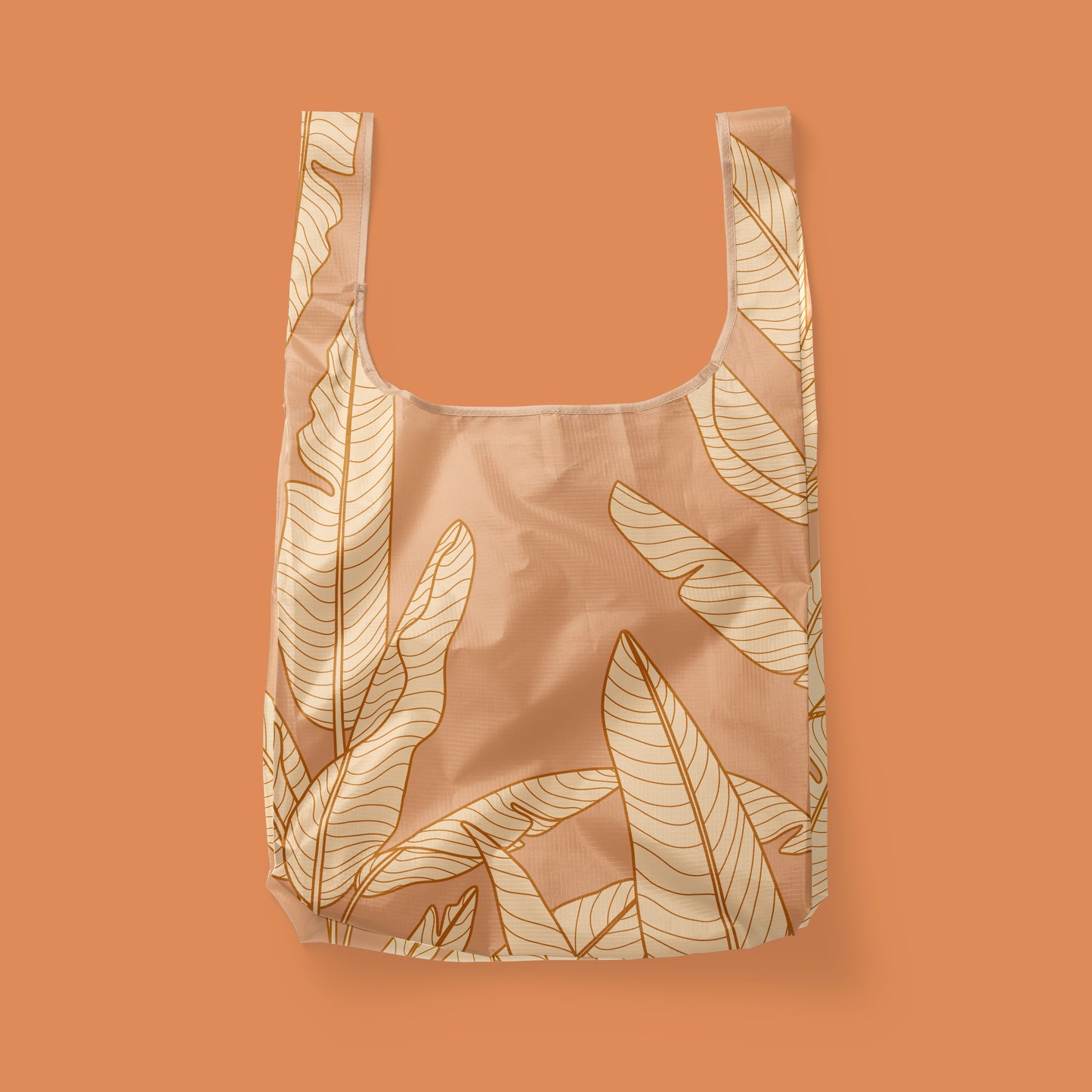 A light orange reusable nylon tote bag with a banana leaf pattern.