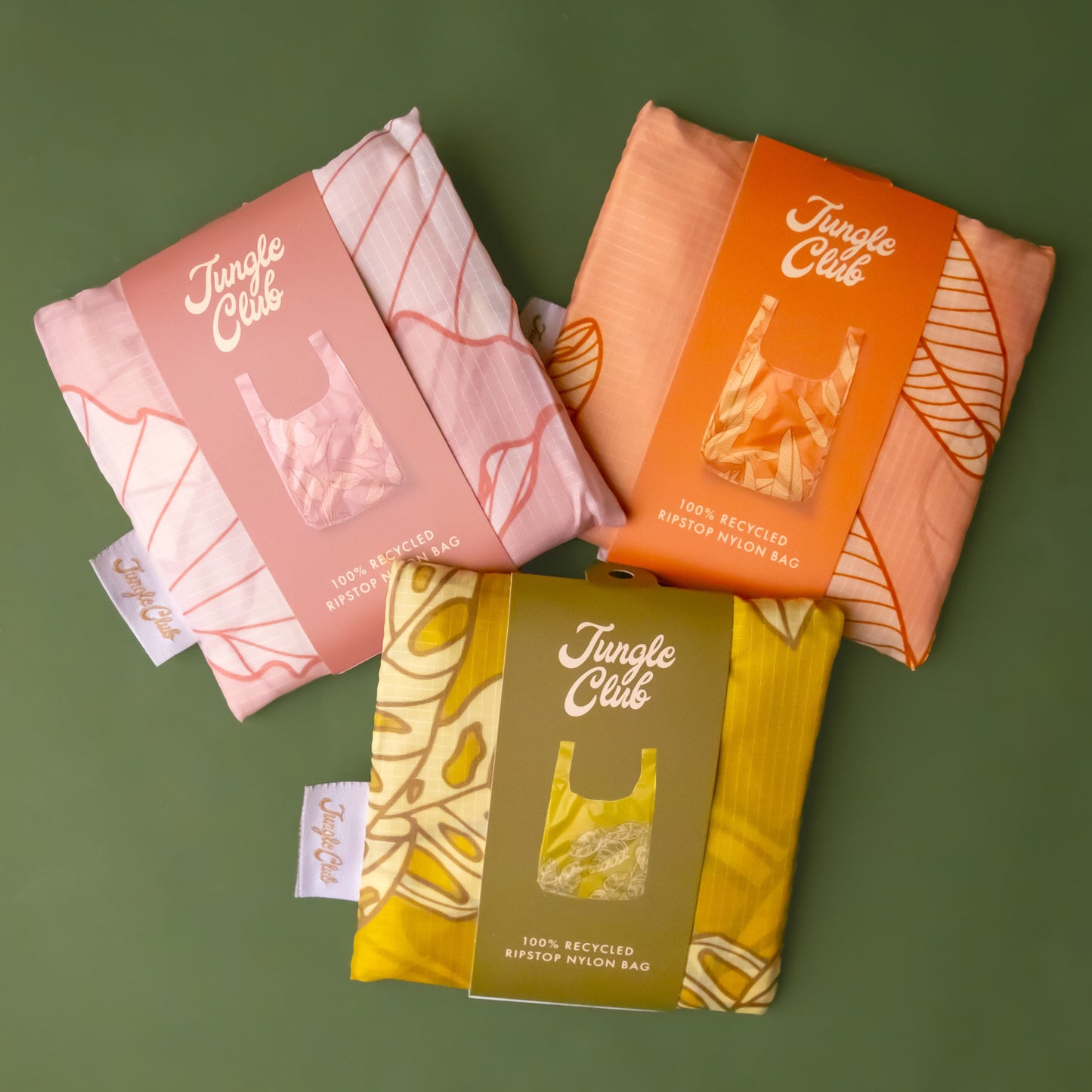 A bundle of three reusable nylon tote bags with different plant patterns on them.
