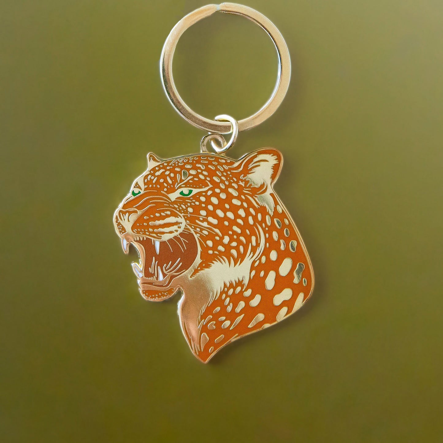 An orange leopard keychain with gold details.