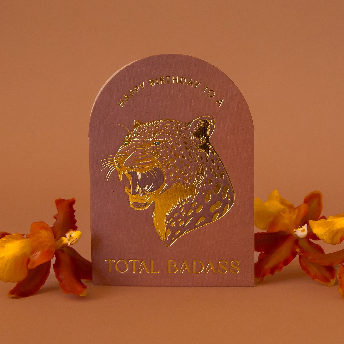 An arched brown card with gold foiled text that reads, 'Happy Birthday to a Total Badass' and a leopard design.