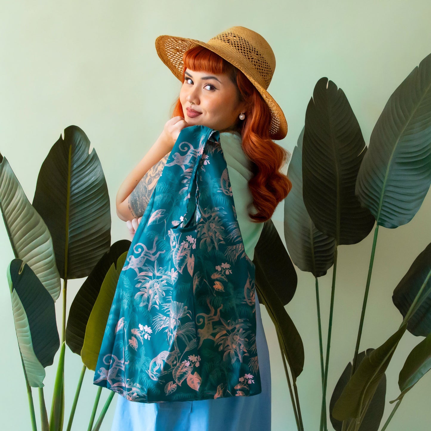 A green and apricot jungle print nylon tote bag.