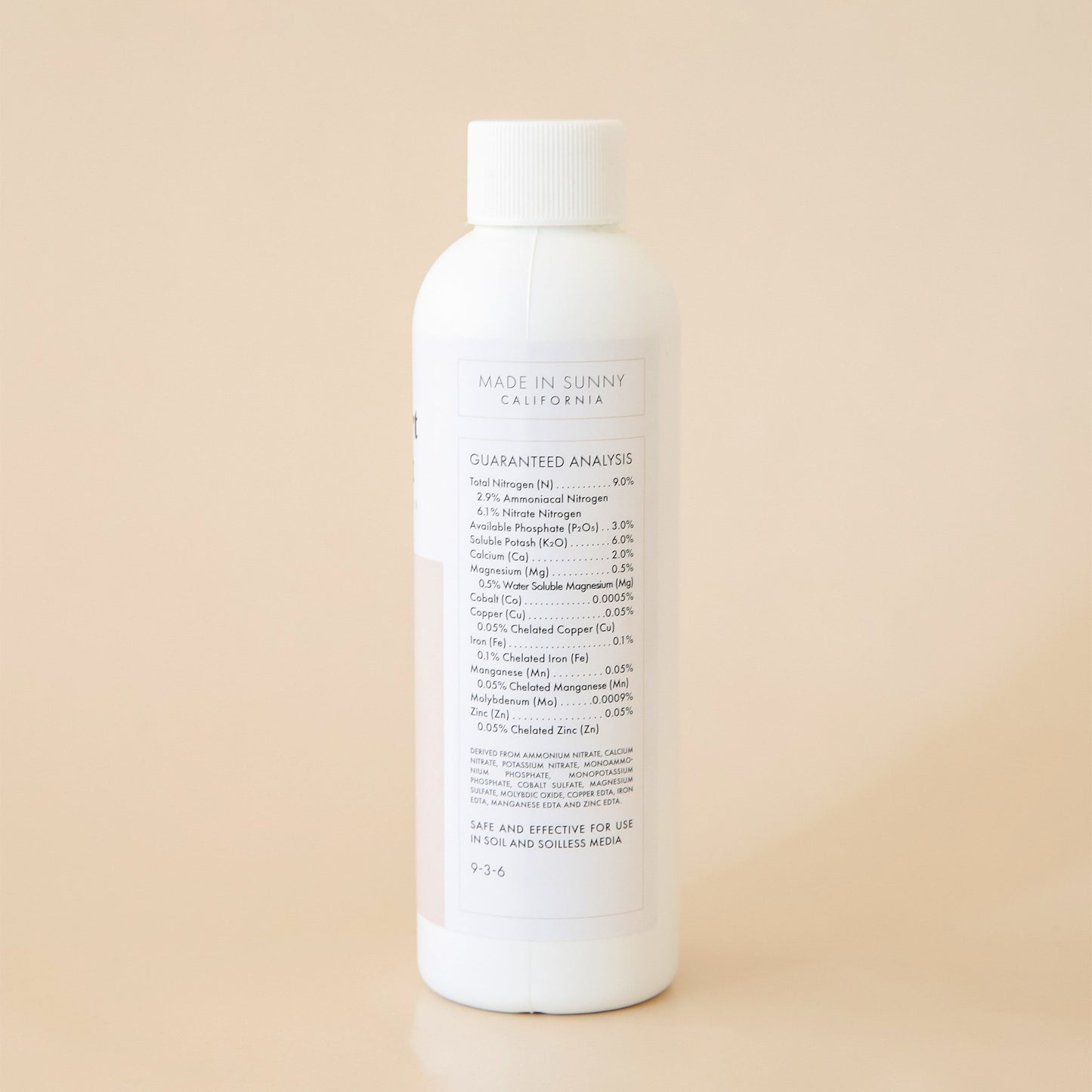 The back side of the bottle reads 'Made in Sunny California' in black capital lettering. Below is a detailed list of ingredients titled 'Guaranteed Analysis'. Both the title and ingredient lists are outlined in a thin, soft beige border. Edit alt text