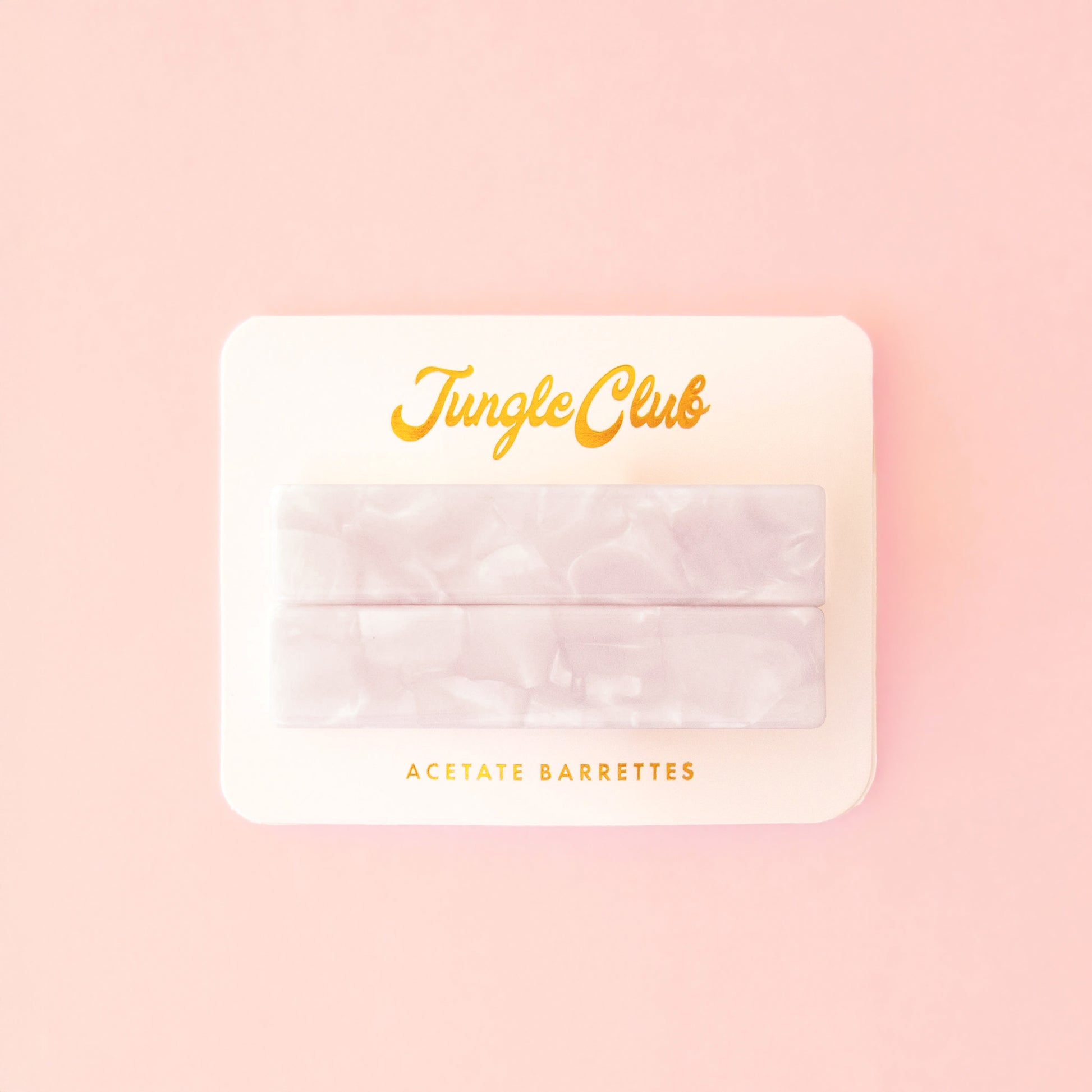 Marbled white acetate barrettes on a pink ground card that reads, "Jungle Club".