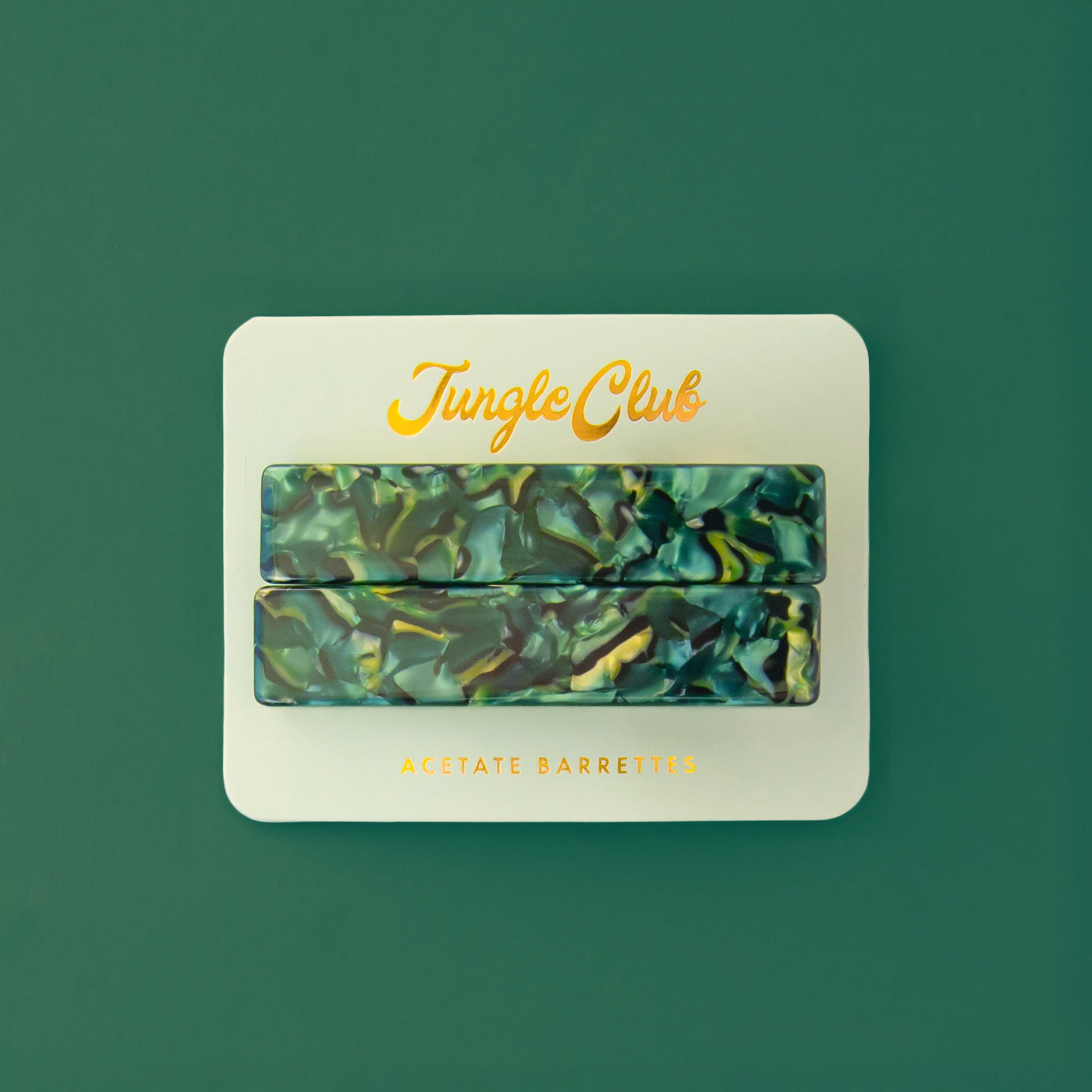 Marbled blue and green acetate barrettes on a mint ground card that reads, "Jungle Club".