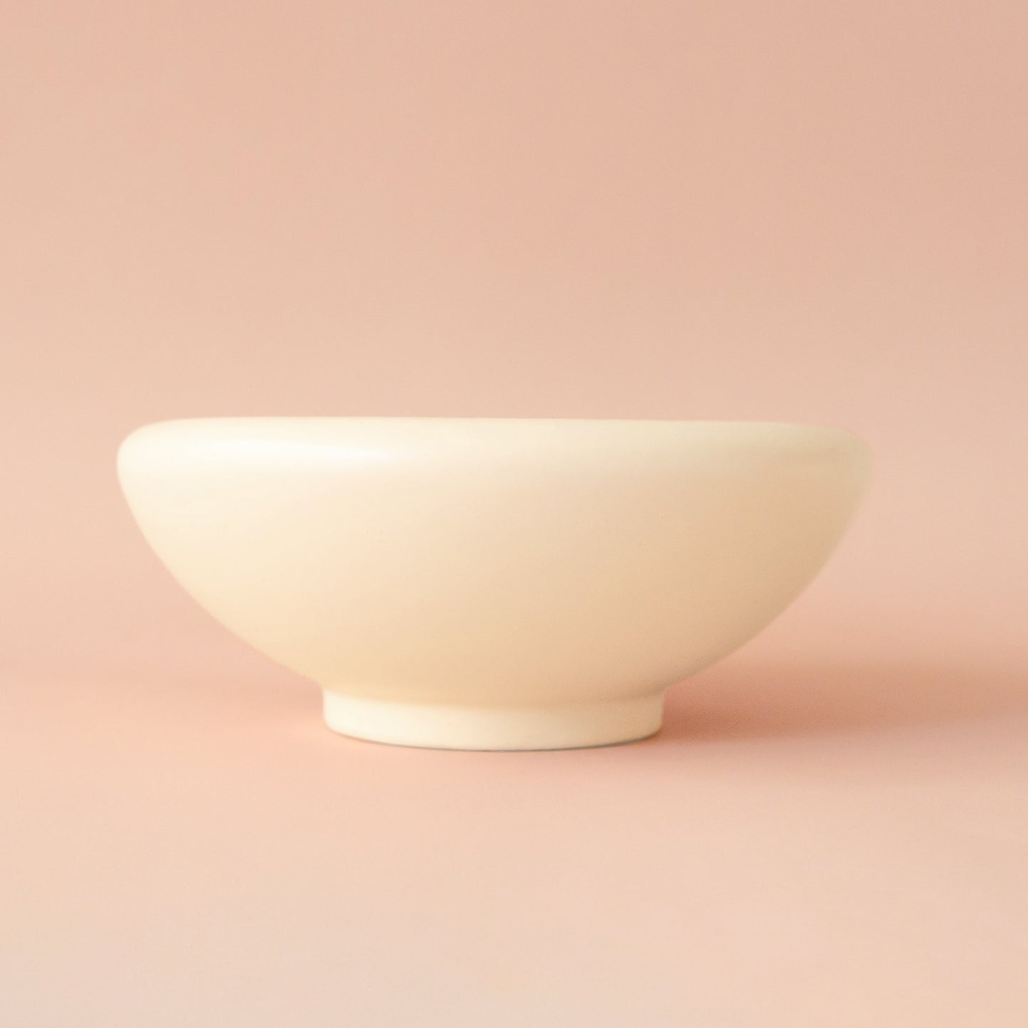 A rounded low pedestal bow in a vintage ivory shade. Plantings are just used for staging purposes and are sold separately. 