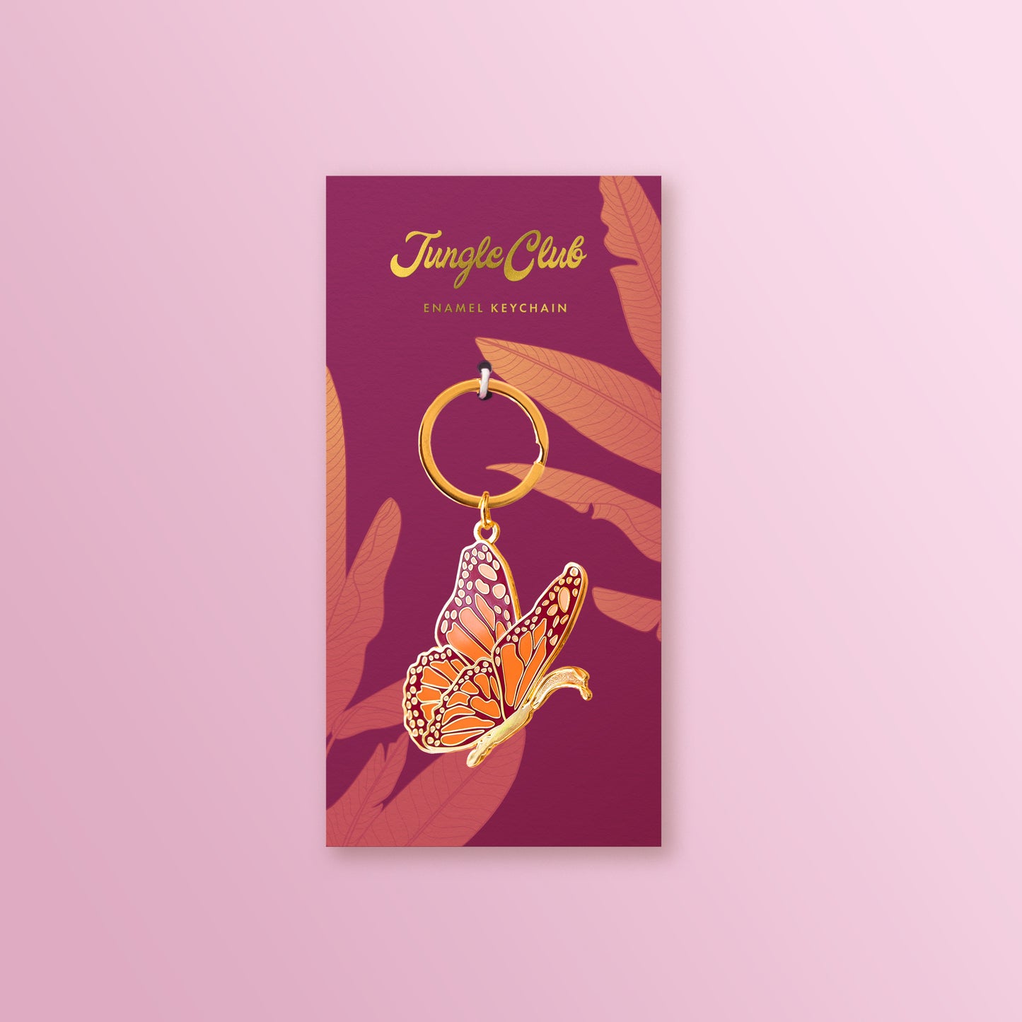 A butterfly keychain on a pink ground with leaf motif.