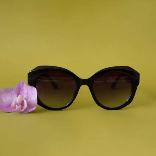 A pair of black round, oversized sunglasses.